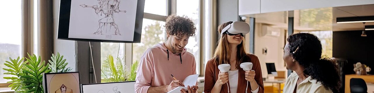 Gruppe von Gaming-VR-Entwicklern, die gemeinsam ihre neue Software im Büro testen