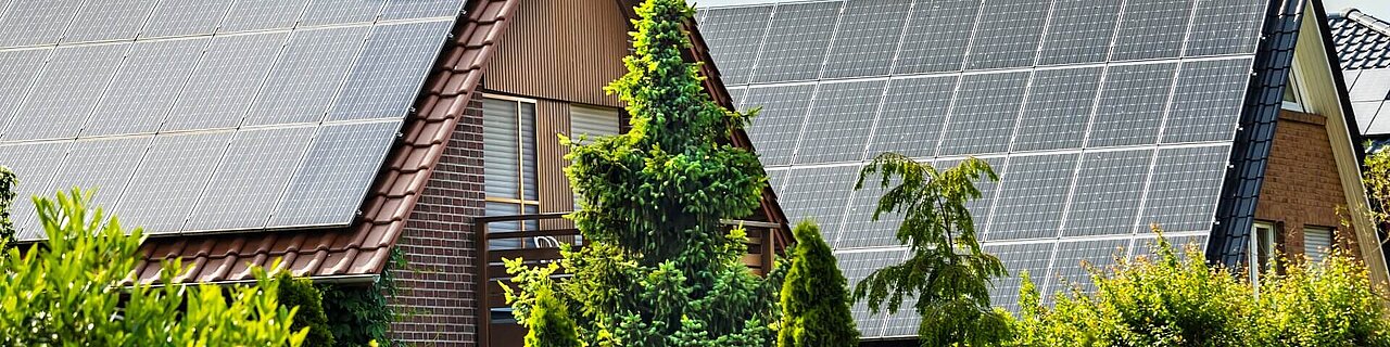 Häuser mit Sonnenkollektoren an einem Sommertag 