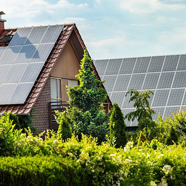 Häuser mit Sonnenkollektoren an einem Sommertag 