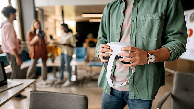Unkenntlicher Mann, der VR Googles in Händen hält