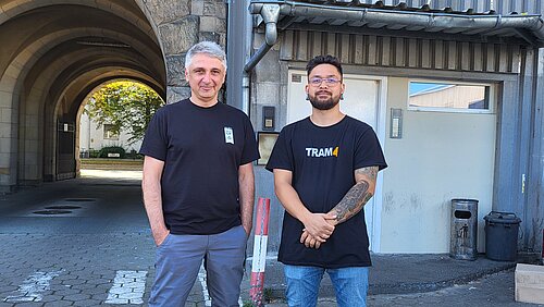 Zwei Mitarbeiter des Unternehmens RiCE UP onigiri stehen in einem Liefereingang.